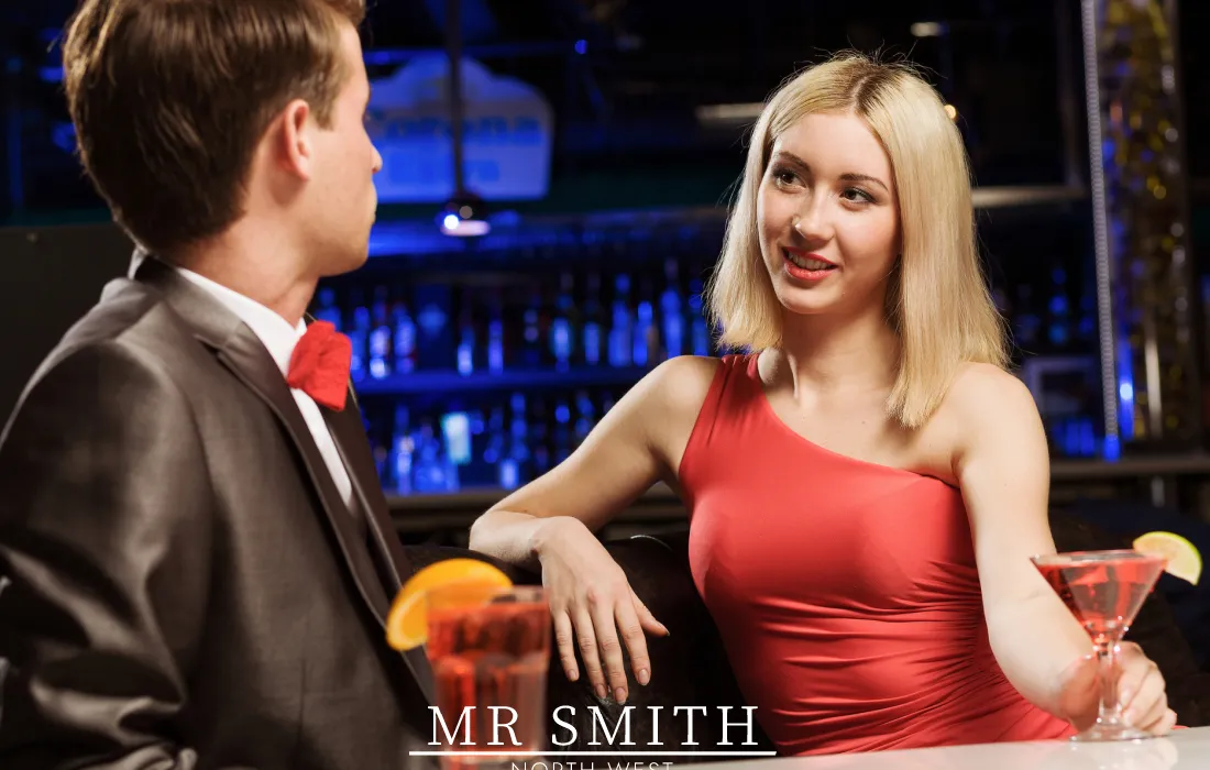 A gentlemen talking to an escort wearing a red dress