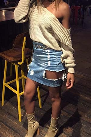 Eve showing off figure in off the shoulder top and ripped denim skirt.